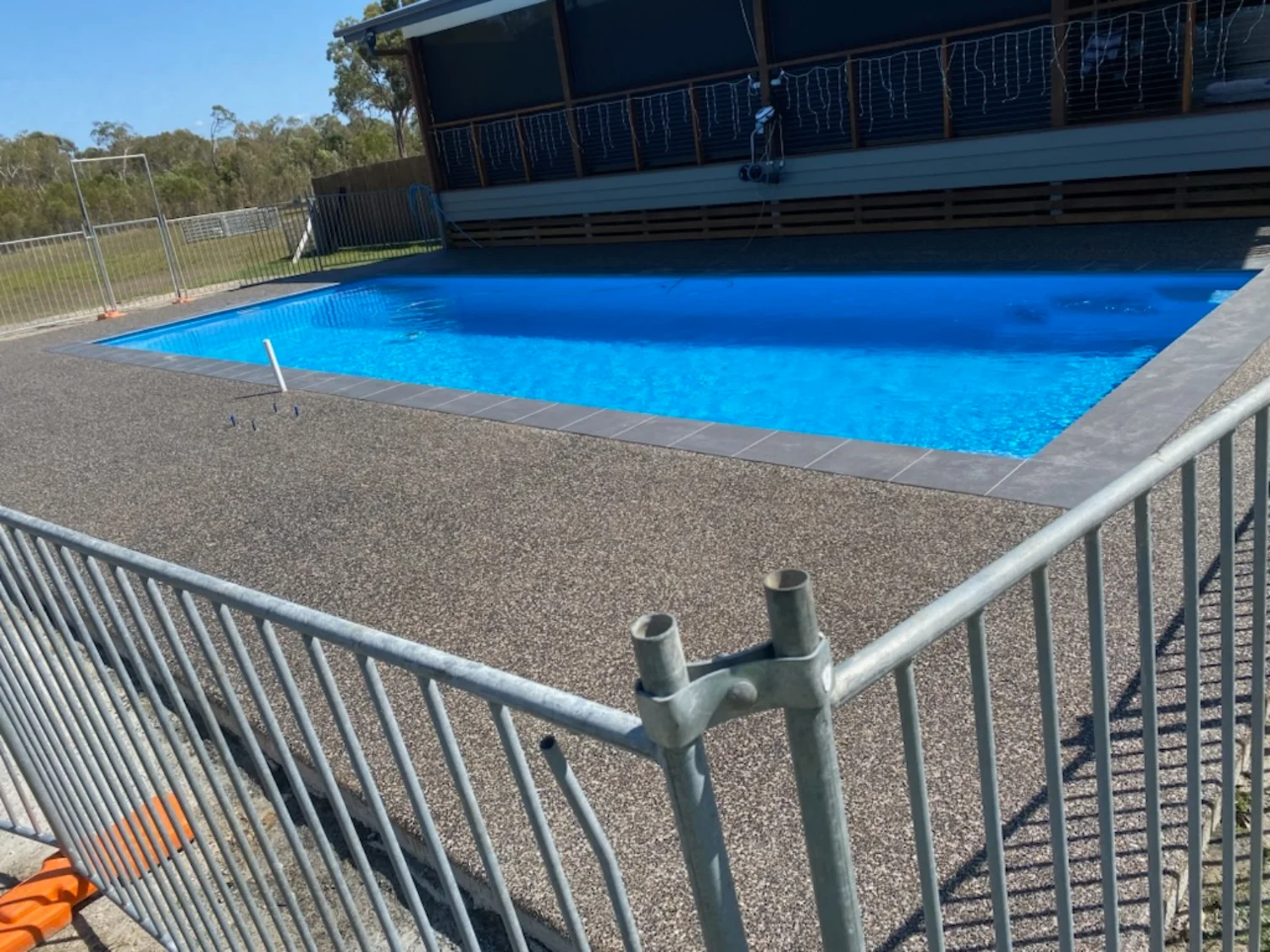 Exposed aggregate concrete pool surround at a rural Hervey Bay property, installed by Mark Holstein Concreting