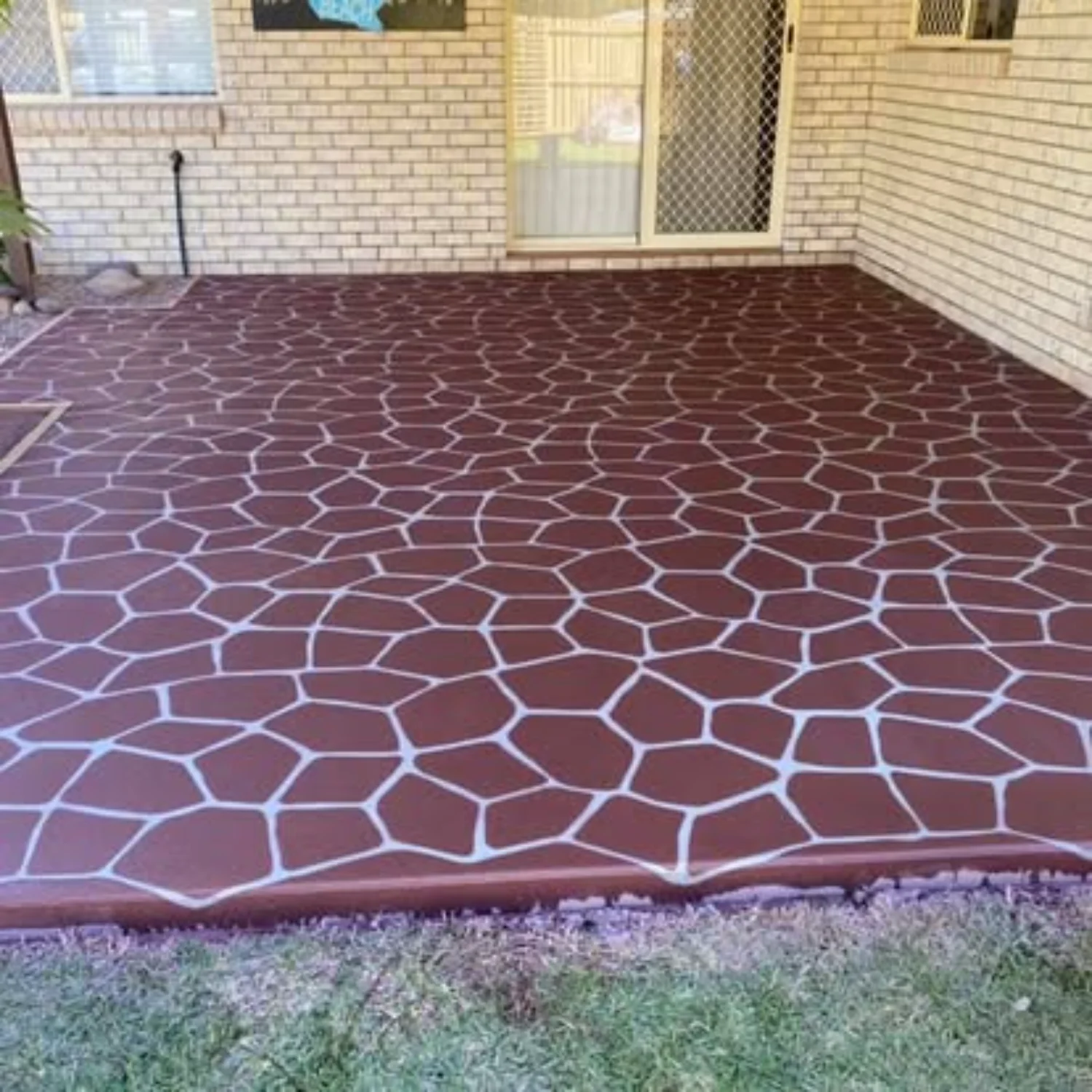Decorative stamped concrete patio with cobblestone pattern by Mark Holstein Concreting outside a Hervey Bay home