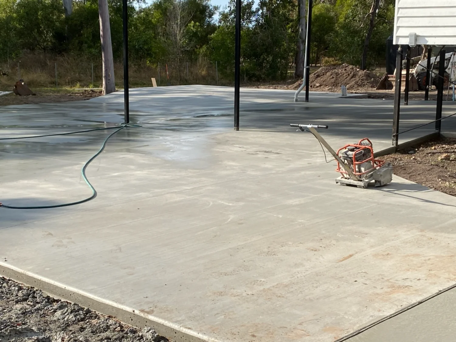 Large concrete shed slab that connects to the driveway and home seen on stilts, poured by Mark Holstein Concreting