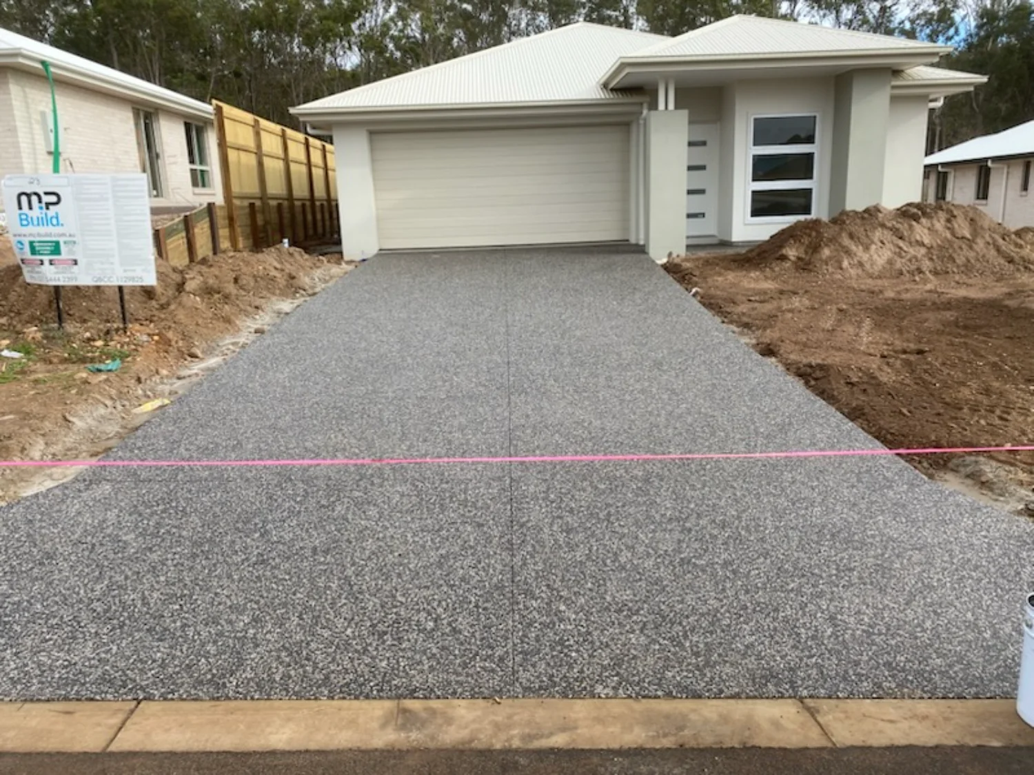 Exposed aggregate concrete driveway at a new residential home in Hervey Bay, installed by Mark Holstein Concreting