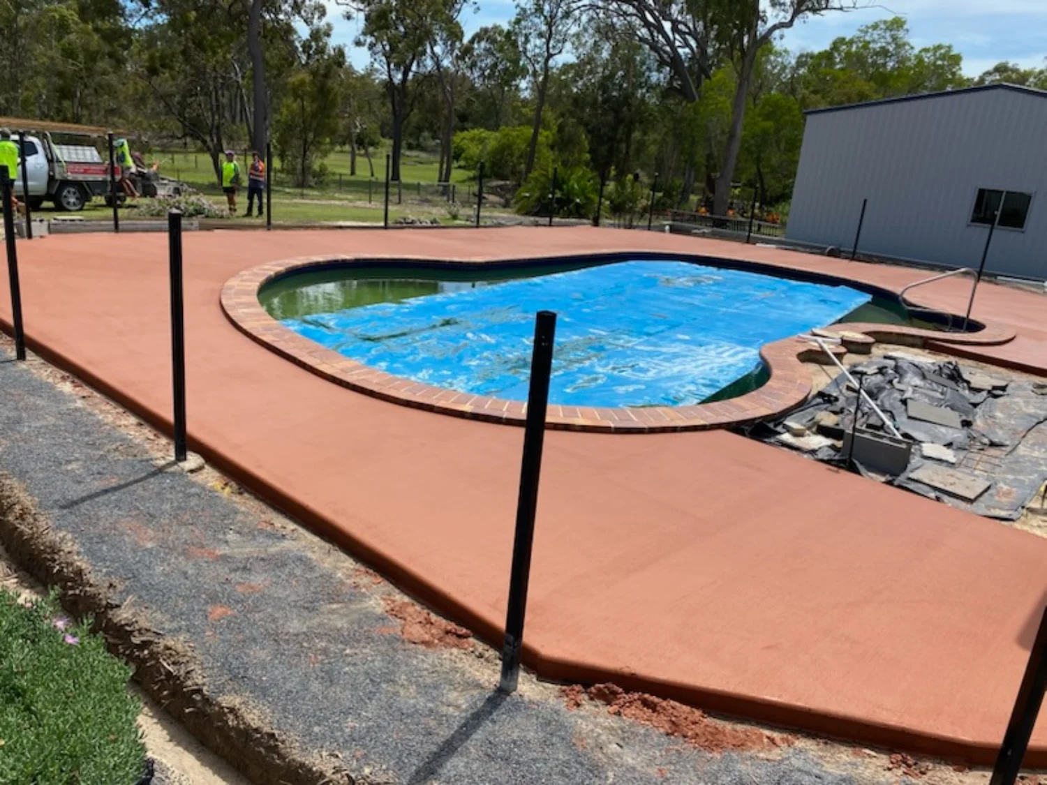 Ochre-coloured concrete pool surrounds installation by Mark Holstein Concreting in Hervey Bay