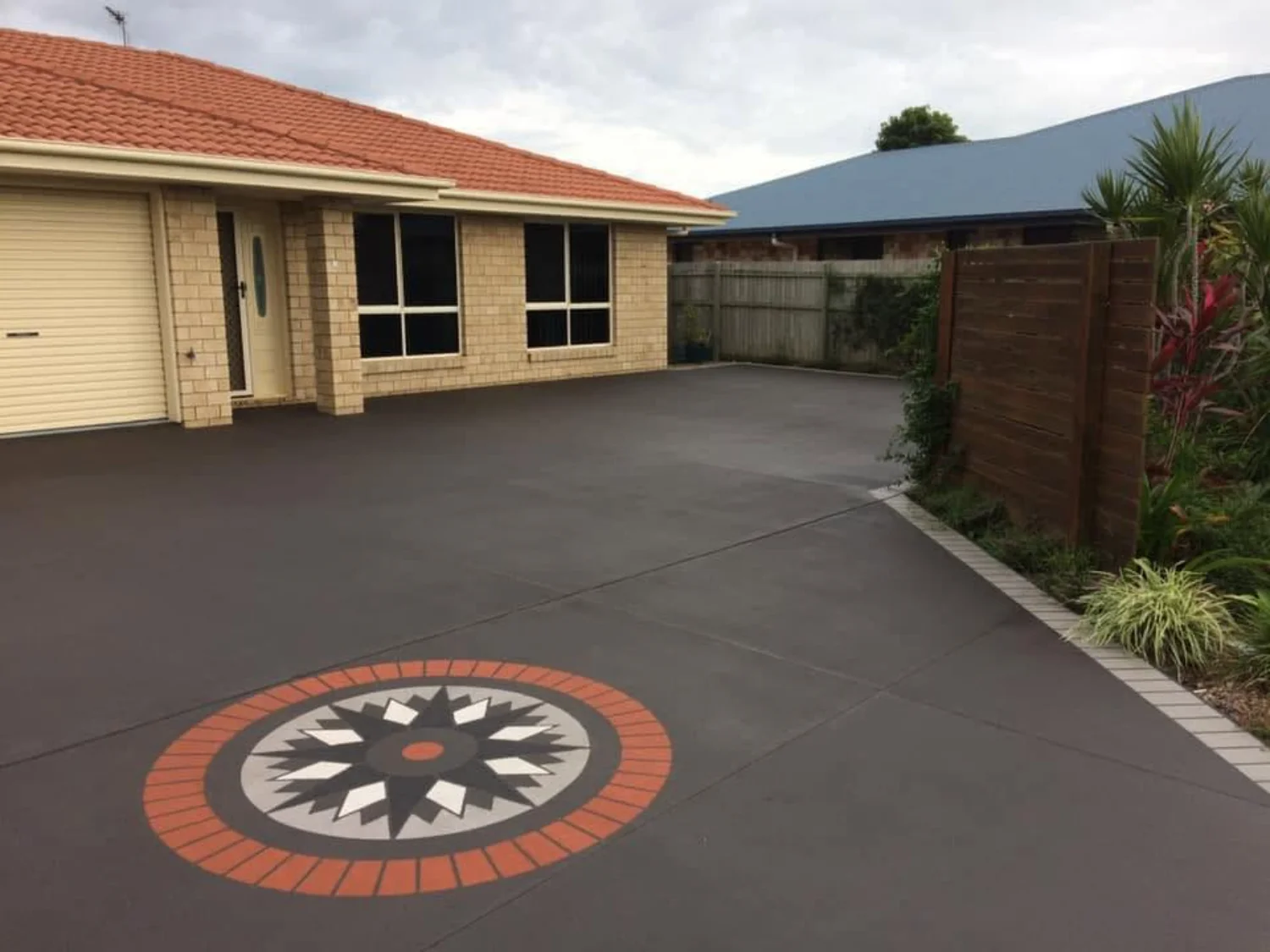 Residential concrete driveway with a decorative geometric design by Mark Holstein Concreting in Hervey Bay